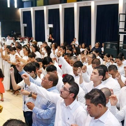 Congregación en oración con las manos unidas